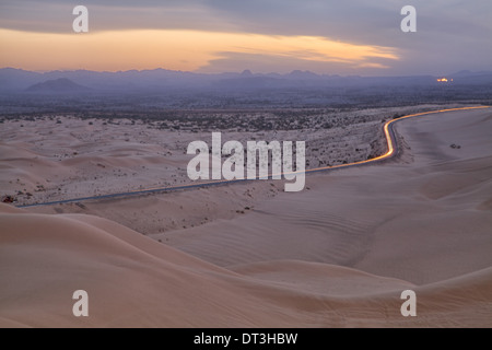 I fari illuminano l'autostrada 78, vicino a Glamis California, all'estremità nord delle dune di sabbia imperiali, a nord-ovest di Yuma Arizona Foto Stock