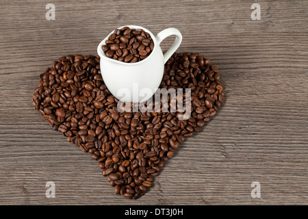 I chicchi di caffè sul racconto di legno a forma di cuore Foto Stock