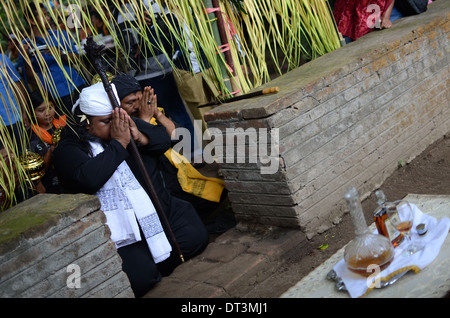 Gli anziani del villaggio che portano il rituale delle offerte di liquore presso la tomba di Prabu Anom Doko nel villaggio. Foto Stock