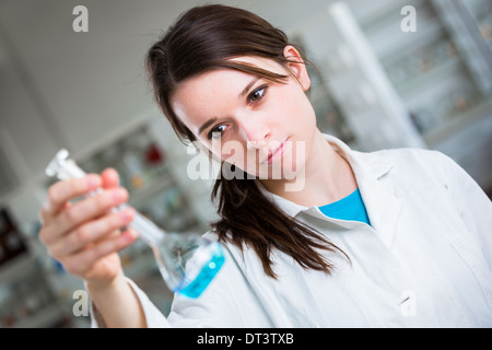 Ritratto di un ricercatore femmina/chimica studente di effettuare la ricerca in un laboratorio di chimica (toni di colore immagine; shallow DOF) Foto Stock