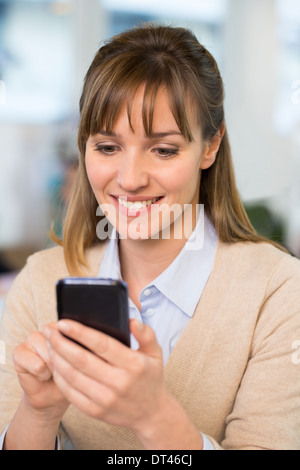 Femmina cella di business desk telefonico digitando Foto Stock