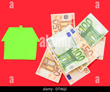 Una casa accanto a un mucchio di euro Foto Stock
