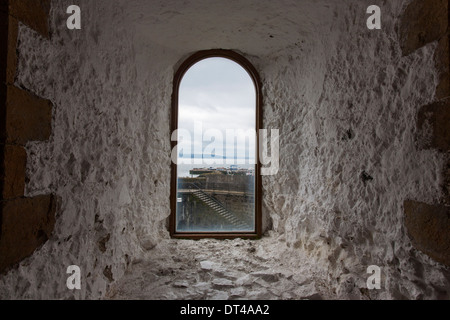La vista di una finestra di dimensioni ridotte in tutta Belfast Lough dal Castello di Carrickfergus, un castello normanno in Irlanda del Nord, Foto Stock