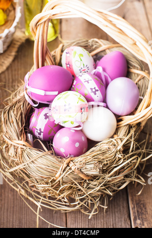 Varie viola le uova nel paniere, decorazioni di Pasqua Foto Stock