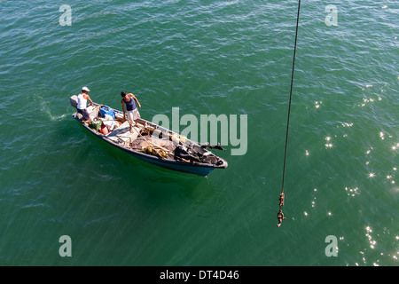 Barche Fishning lanciato e recuperato mediante gru dal molo di pesca in La Libertad, una città portuale sulla costa di El Salvador Foto Stock