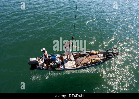 Barche da pesca lanciato e recuperato mediante gru dal molo di pesca in La Libertad, una città portuale sulla costa di El Salvador Foto Stock