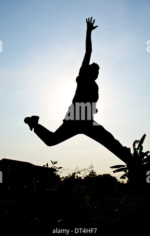 Silhouette di uomo salto per felice e vittoria Foto Stock