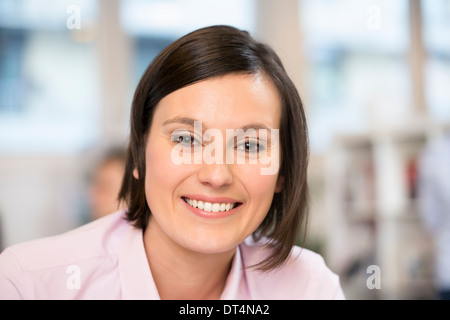 Donna sorridente di business desk faccia di lavoro Foto Stock