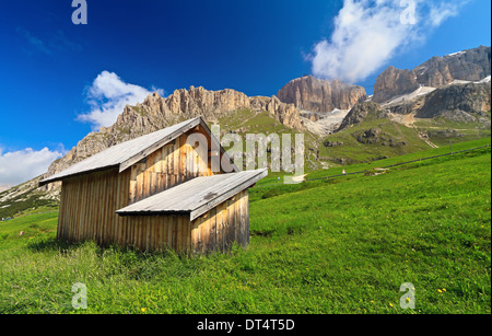 Piccolo fienile sotto le montagne delle Dolomiti, Passo Pordoi, Trentino, Italia Foto Stock