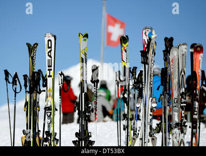 Fiesch, Svizzera. 06 feb 2014. Sci visto di fronte alla bandiera svizzera durante una giornata di sole vicino all'Eggishorn montagna vicino a Fiesch, Svizzera, 06 febbraio 2014. Foto: Ralf Hirschberger/dpa - nessun filo servizio/dpa/Alamy Live News Foto Stock