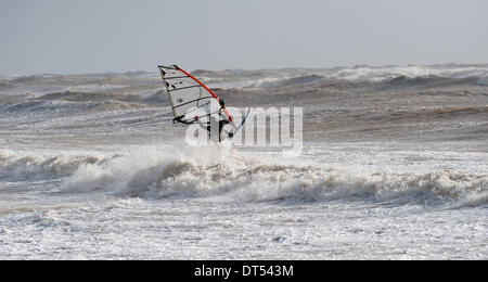 Un windsurf battaglie contro le onde off Tide Mills beach Newhaven oggi come tempeste continuare a pastella costa meridionale della Gran Bretagna Foto Stock