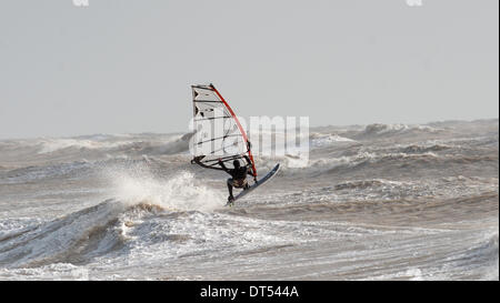 Un windsurf battaglie contro le onde off Tide Mills beach Newhaven oggi come tempeste continuare a pastella costa meridionale della Gran Bretagna Foto Stock