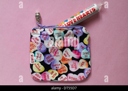 Borsetta Love Hearts con pacchetto tubo di Swizzels Matlow Love Hearts dolci isolati su sfondo rosa - dolcetti Loveheart dall'alto Foto Stock