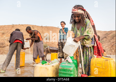 Bambini raccolta di acqua da un pozzo, Berhale, Etiopia, Africa Foto Stock