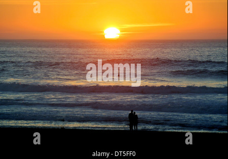 Giovane guardate il tramonto sull'oceano pacifico a Ocean Beach in San francisco Foto Stock