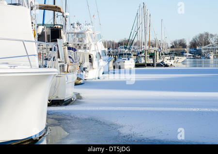 Motore e barche a vela congelati in come Annapolis Harbour ricoperto di ghiaccio. Foto Stock