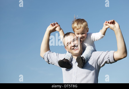 Papà dando il suo giovane figlio un piggy back ride Foto Stock