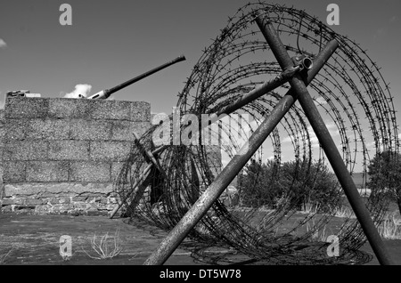 Avvolto il filo spinato su una pistola emplacement. Immagine in bianco e nero. Foto Stock