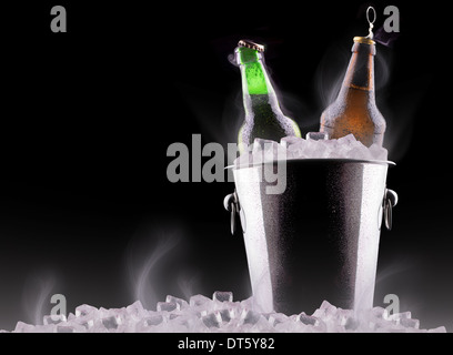 Bottiglie di birra nel secchiello del ghiaccio isolato su nero Foto Stock