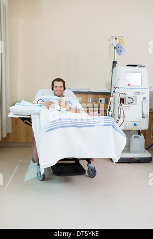 Paziente ascolto musica mentre la ricezione di dialisi renale Foto Stock