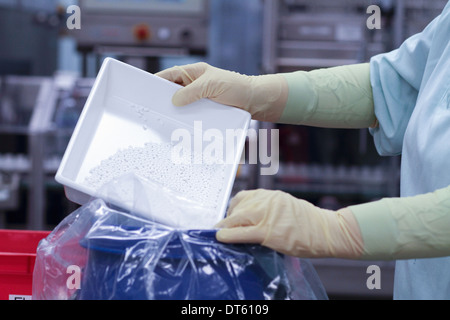 Tecnico di laboratorio compresse di svuotamento in busta di plastica Foto Stock