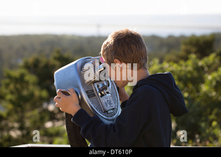 Boy utilizzando a gettone binocolo Foto Stock