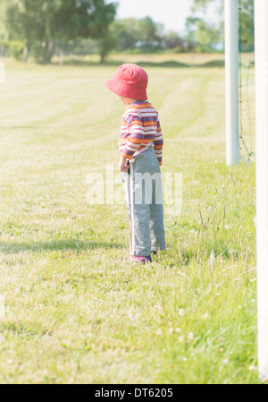 Giovane ragazza che gioca con la rete del gioco del calcio (calcio) obiettivo Foto Stock