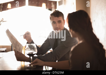 Business Partner guardando il contratto in un wine bar Foto Stock