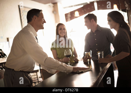 Gli amici sorseggiando un drink nel bar del vino Foto Stock