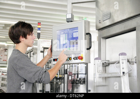 L'uomo utilizzando il pannello di controllo in fabbrica di birra Foto Stock