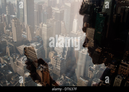 L'uomo tramite telefono cellulare contro cityscape, New York, Stati Uniti d'America Foto Stock