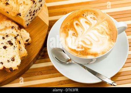 Tazza di cappuccino e torte su sfondo di legno Foto Stock