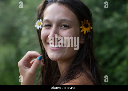 Ragazza adolescente indossando i fiori nei capelli Foto Stock