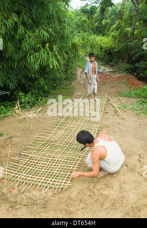 Bangladesh, Asia del Sud, sulle colline di Chittagong, Khagrachari, due uomini tessitura di un grande recinto di bambù pannello. Foto Stock