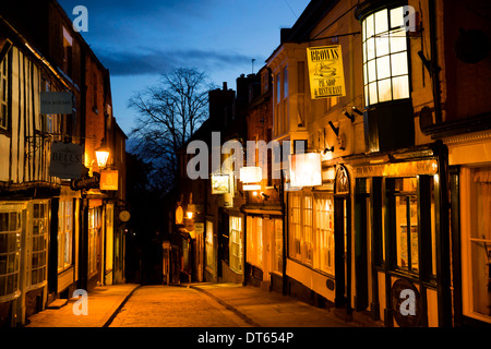 Negozi ed edifici sulla parte superiore della collina ripida, vicino la Cattedrale di Lincoln City Centre, fotografia scattata al tramonto. Foto Stock