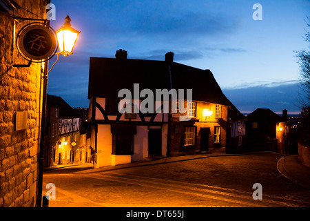 Negozi ed edifici sulla parte superiore della collina ripida, vicino la Cattedrale di Lincoln City Centre, fotografia scattata al tramonto. Foto Stock