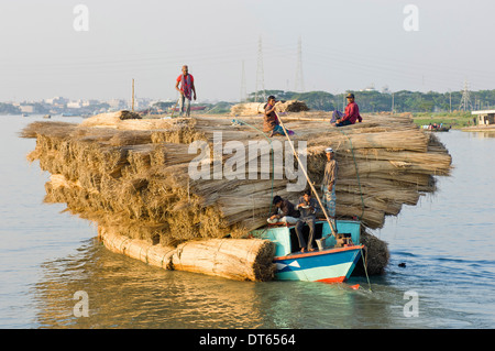 Bangladesh, Asia del Sud, barca molto carico con un carico di iuta steli sul fiume. Foto Stock