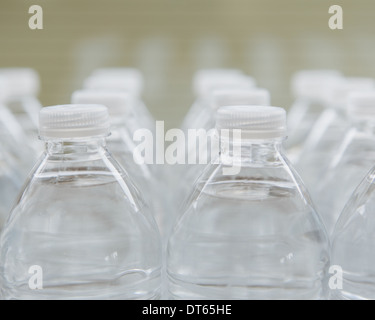 Righe di acqua-riempito di bottiglie di plastica con tappo a vite. Foto Stock