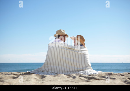Giovane indossando cappelli di paglia sulla spiaggia Foto Stock
