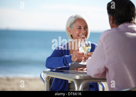 Giovane godendo di vino da parte di mare Foto Stock