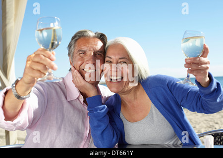 Giovane godendo di vino da parte di mare Foto Stock