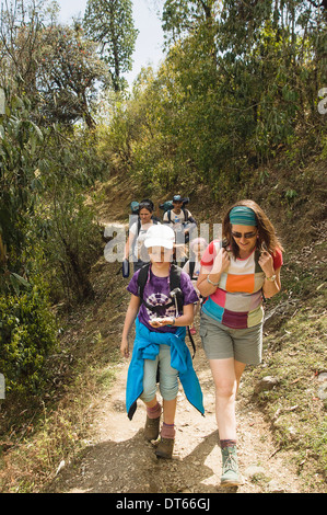 Il Nepal, Asia del Sud, a Pokhara. Western famiglia con bambini trekking in dell'himalaya nepalese sulle colline vicino a Pokhara. Foto Stock