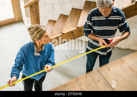 Coppia senior facendo DIY, utilizzando nastro di misurazione Foto Stock