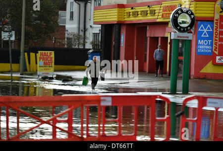 Oxford, Oxfordshire, Regno Unito. 10 Febbraio, 2014. Yim Kong tenta di tornare al suo lavoro nel centro di Oxford Le acque di esondazione aumento in Oxford chiusura Abingdon Road per la seconda volta nel 2014 causando più problemi di trasporto per la città. Sebbene la pioggia ha mollare, previsioni meteo prevedere ulteriori docce attraverso il resto della settimana. Credito: Sidney Bruere/Alamy Live News Foto Stock