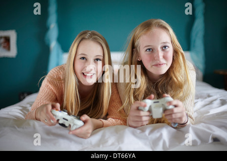 Due ragazze adolescenti giocando sul gioco per computer in camera da letto Foto Stock