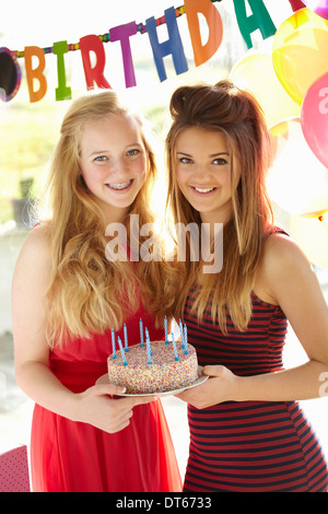 Due ragazze adolescenti holding torta di compleanno Foto Stock