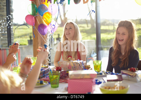 Quattro ragazze adolescenti celebrando con bolle a festa di compleanno