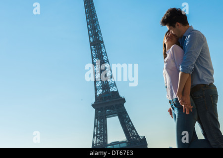 Coppia giovane abbracciando vicino alla Torre Eiffel, Parigi, Francia Foto Stock