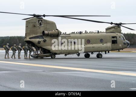 Grafenwoehr, Germania. 10 Febbraio, 2014. I soldati dell'Esercito USA immettere un Boeing CH-47 elicottero Chinook in corrispondenza della zona di formazione di Grafenwoehr, Germania, 10 febbraio 2014. Circa 350 soldati scavalcato da circa 330 metri sopra il livello del mare da un elicottero militare. Il corso di formazione prepara il 173rd Brigata Aerea per ulteriori operazioni. L'unità è già stata impiegata nelle zone di guerra in Iraq e in Afghanistan. Foto: ARMIN WEIGEL/dpa/Alamy Live News Foto Stock