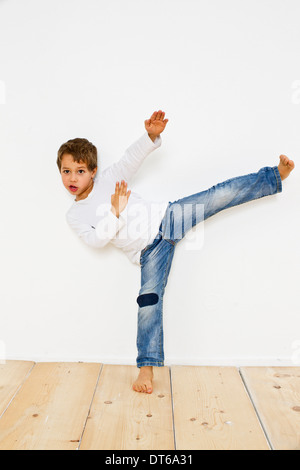 Studio shot di boy praticare il karate kick Foto Stock